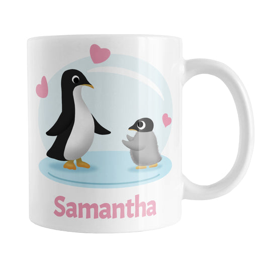 Personalized My Little Penguin Mug (11oz) at Amy's Coffee Mugs. A ceramic coffee mug designed with an illustration of a mommy or daddy penguin with a little baby penguin over a blue background design with three pink hearts above them. Your name is personalized in pink below the adorable penguins. This cute penguin illustration and personalization is on both sides of the mug.