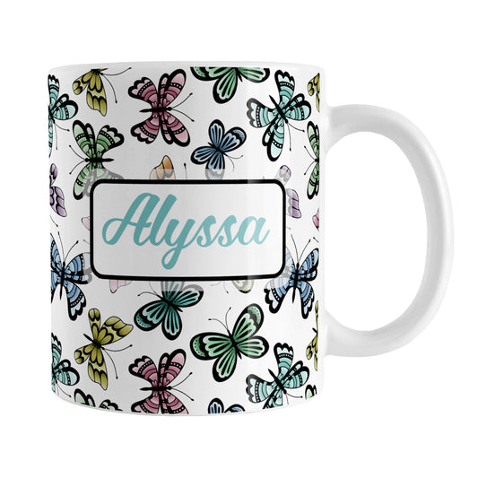 Personalized Pretty Butterfly Pattern Mug (11oz) at Amy's Coffee Mugs. A ceramic coffee mug designed with pretty and colorful butterflies in a pattern that wraps around the mug to the handle. Your name is personalized in turquoise on both sides of the mug.