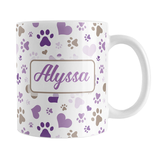 Personalized Purple Hearts and Paw Prints Mug (11oz) at Amy's Coffee Mugs. A ceramic coffee mug designed with a pattern of hearts and paw prints in brown and different shades of purple that wraps around the mug to the handle. Your personalized name is printed in purple on both sides of the mug, making it the perfect gift. This mug is perfect for people love dogs and cute paw print designs.