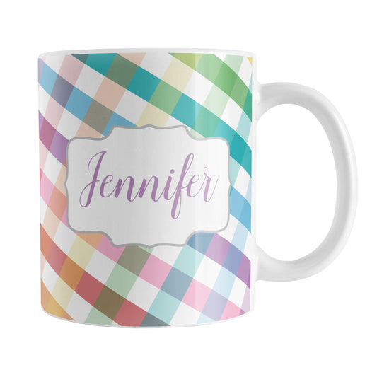 Personalized Rainbow Gingham Mug (11oz) at Amy's Coffee Mugs. A ceramic coffee mug designed with a slanted gingham pattern with a colorful rainbow progression that wraps around the mug up to the handle. Your personalized name is printed in a pretty purple script font in a white frame design on both sides of the mug over the rainbow gingham pattern.