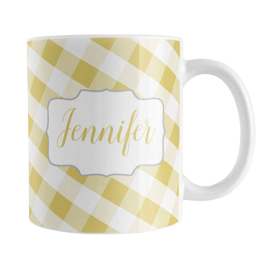 Personalized Yellow Gingham Mug (11oz) at Amy's Coffee Mugs. A ceramic coffee mug designed with a slanted yellow and white gingham pattern that wraps around the mug up to the handle. Your personalized name is custom-printed in a yellow script font on both sides of the mug over the gingham pattern.