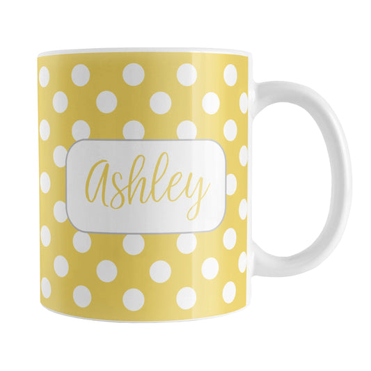 Personalized Yellow Polka Dot Mug (11oz) at Amy's Coffee Mugs. A ceramic coffee mug designed with a pattern of white polka dots over a yellow background color that wraps around the mug up to the handle. Your name is personalized in a cute yellow script font in a white frame design on both sides of the mug over the polka dot pattern.