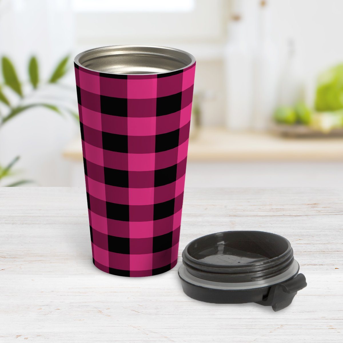 Pink and Black Buffalo Plaid Travel Mug at Amy's Coffee Mugs. A travel mug designed with a dark raspberry pink and black buffalo plaid pattern that wraps around the mug. Photo shows the mug open on a table with its lid beside it.
