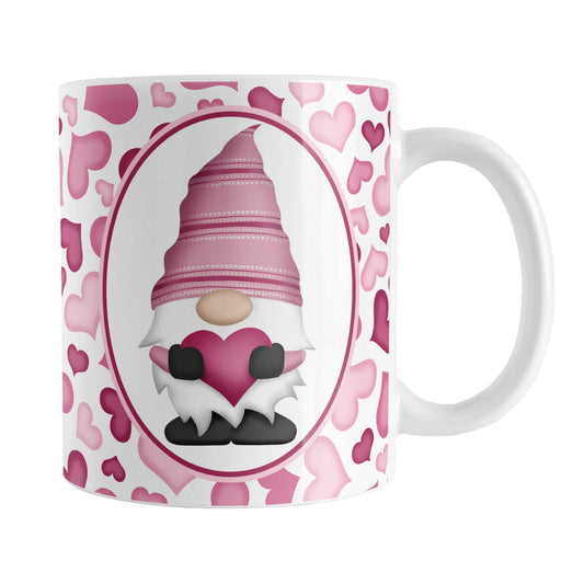 Pink Gnome Hearts Mug (11oz) at Amy's Coffee Mugs. A ceramic coffee mug designed with an adorable pink gnome in a white oval on both sides of the mug over a pattern of cute hearts in different shades of pink that wrap around the mug to the handle.