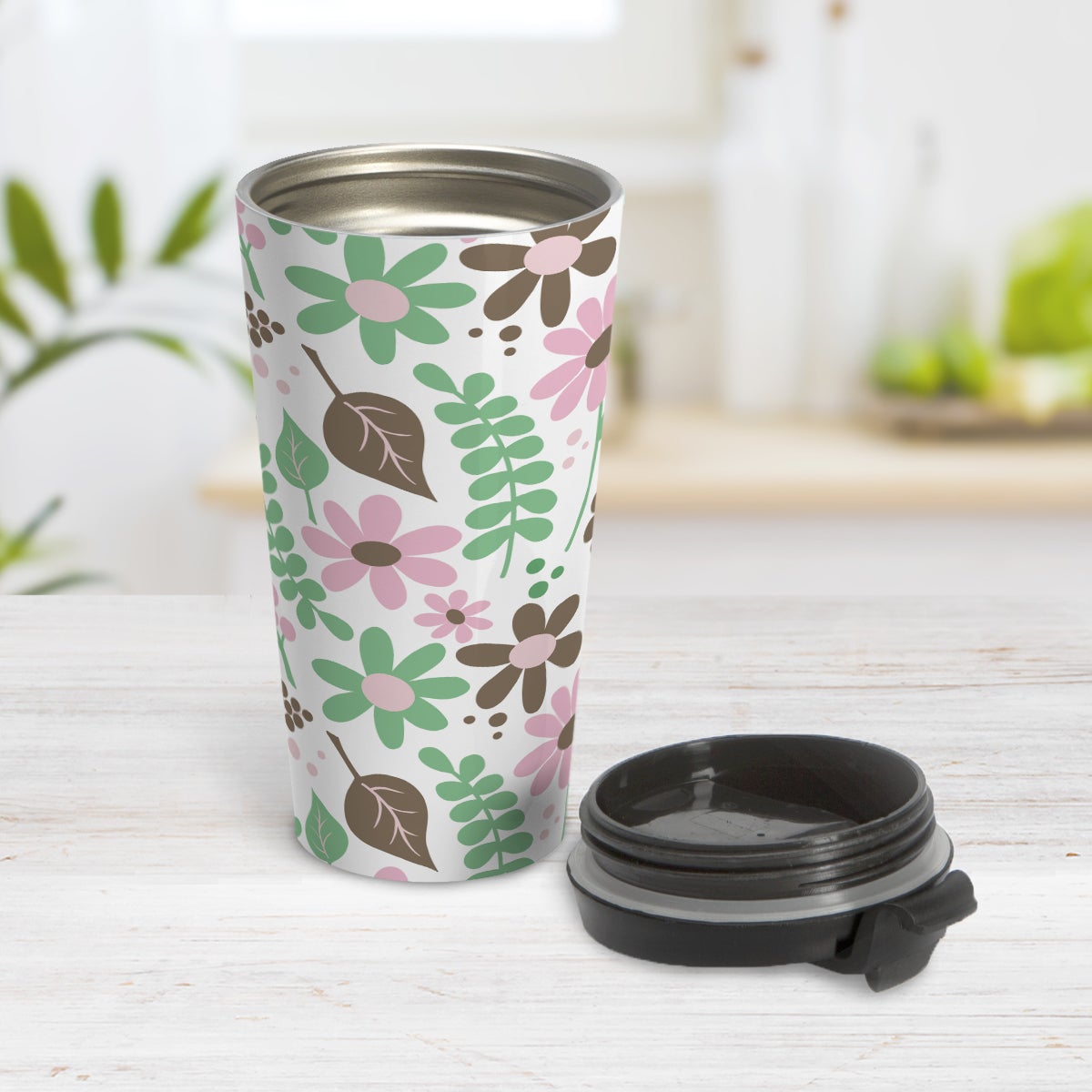 Pink Green Brown Floral Pattern Travel Mug (15oz) at Amy's Coffee Mugs. A travel mug designed with flowers and leaves in pink, green, and brown in a pretty floral pattern that wraps around the mug. Photo shows the mug open on a table with its lid beside it.