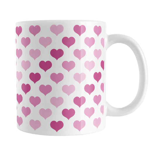 Pink Hearts Pattern Mug (11oz) at Amy's Coffee Mugs. A ceramic coffee mug designed with a pattern of hearts in three different shades of pink that wraps around the mug up to the handle.