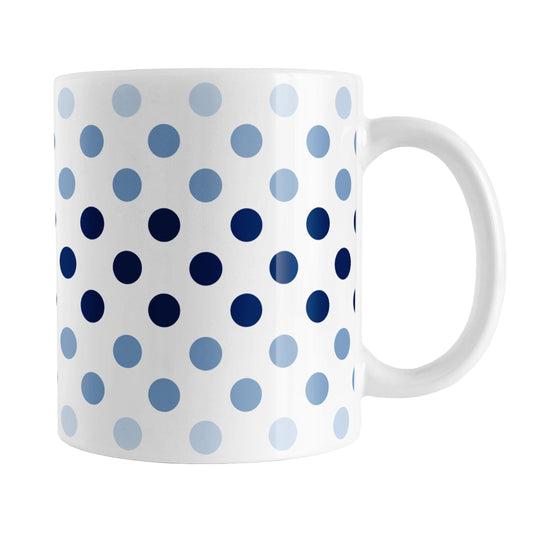 Polka Dots in Blue Mug (11oz) at Amy's Coffee Mugs. A ceramic coffee mug designed with polka dots in different shades of blue, with the darker blue color across the middle and the lighter blue along the top and bottom, in a pattern that wraps around the mug to the handle.