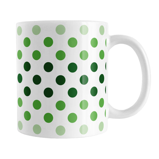 Polka Dots in Green Mug (11oz) at Amy's Coffee Mugs. A ceramic coffee mug designed with polka dots in different shades of green, with the darker green color across the middle and the lighter green along the top and bottom, in a pattern that wraps around the mug to the handle.