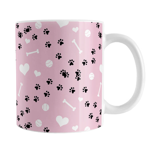 Puppy Run Pink Dog Mug (11oz) at Amy's Coffee Mugs. A ceramic coffee mug designed with a pattern of chaotic tracks of puppy paw prints running around the mug with white dog bones, balls, and hearts over a light pink background. This mug is perfect for people who love the chaotic play of puppies, love dogs, and like pink mugs.