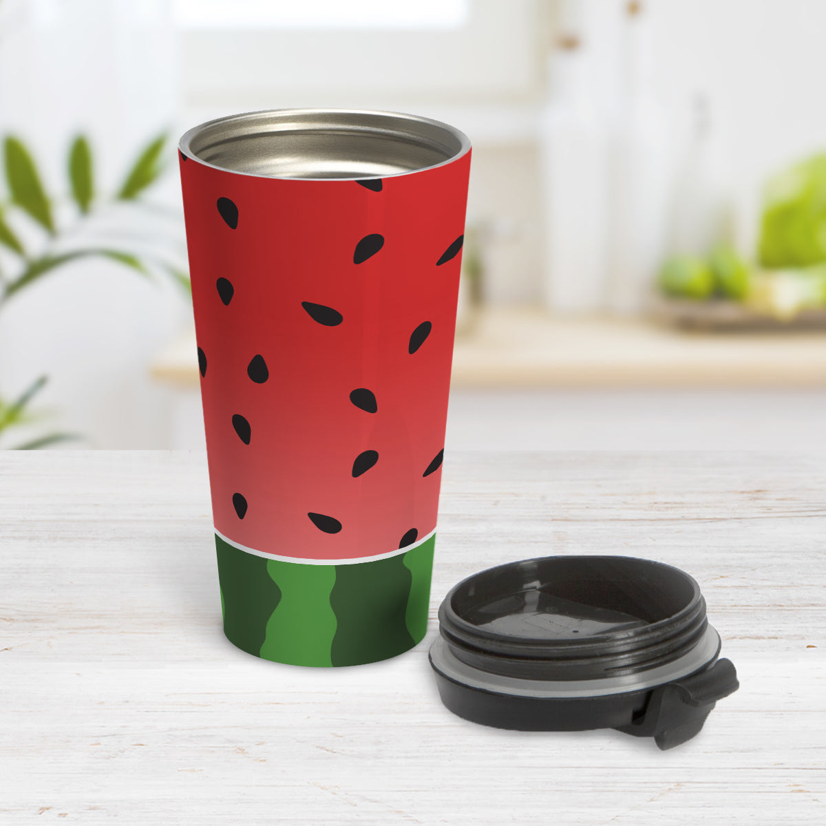 Red and Green Watermelon Travel Mug (15oz, stainless steel insulated) at Amy's Coffee Mugs. A travel mug designed with a watermelon black seed pattern complemented by a green stripe watermelon pattern along the bottom. This fruity design wraps around the travel mug. Photo shows the mug open on a table with its lid beside it.