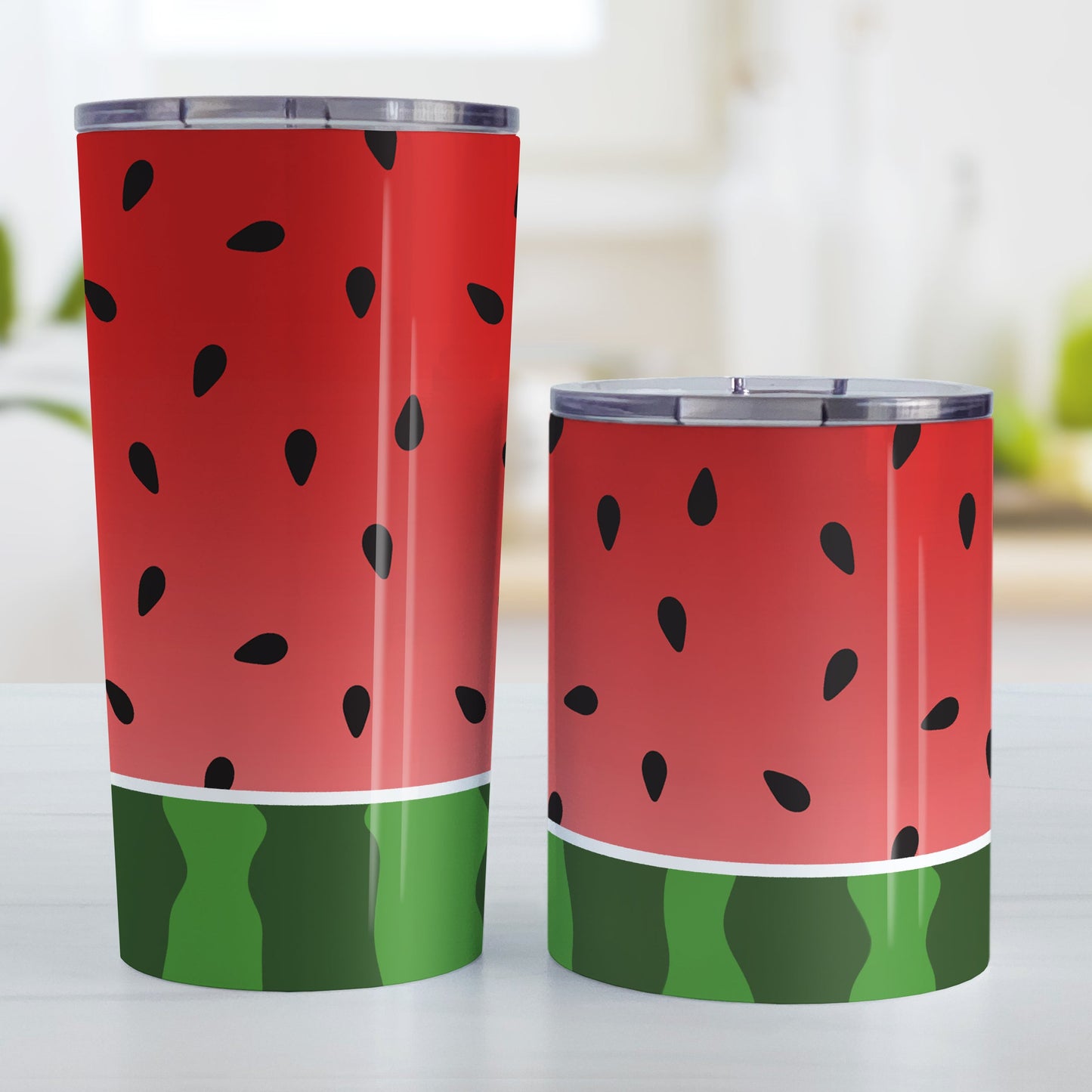 Red and Green Watermelon Tumbler Cup (20oz and 10oz, stainless steel insulated) at Amy's Coffee Mugs. A tumbler cup designed with a watermelon black seed pattern complemented by a green stripe watermelon pattern along the bottom. This fruity design wraps around the cup. Photo shows both sized cups on a table next to each other.