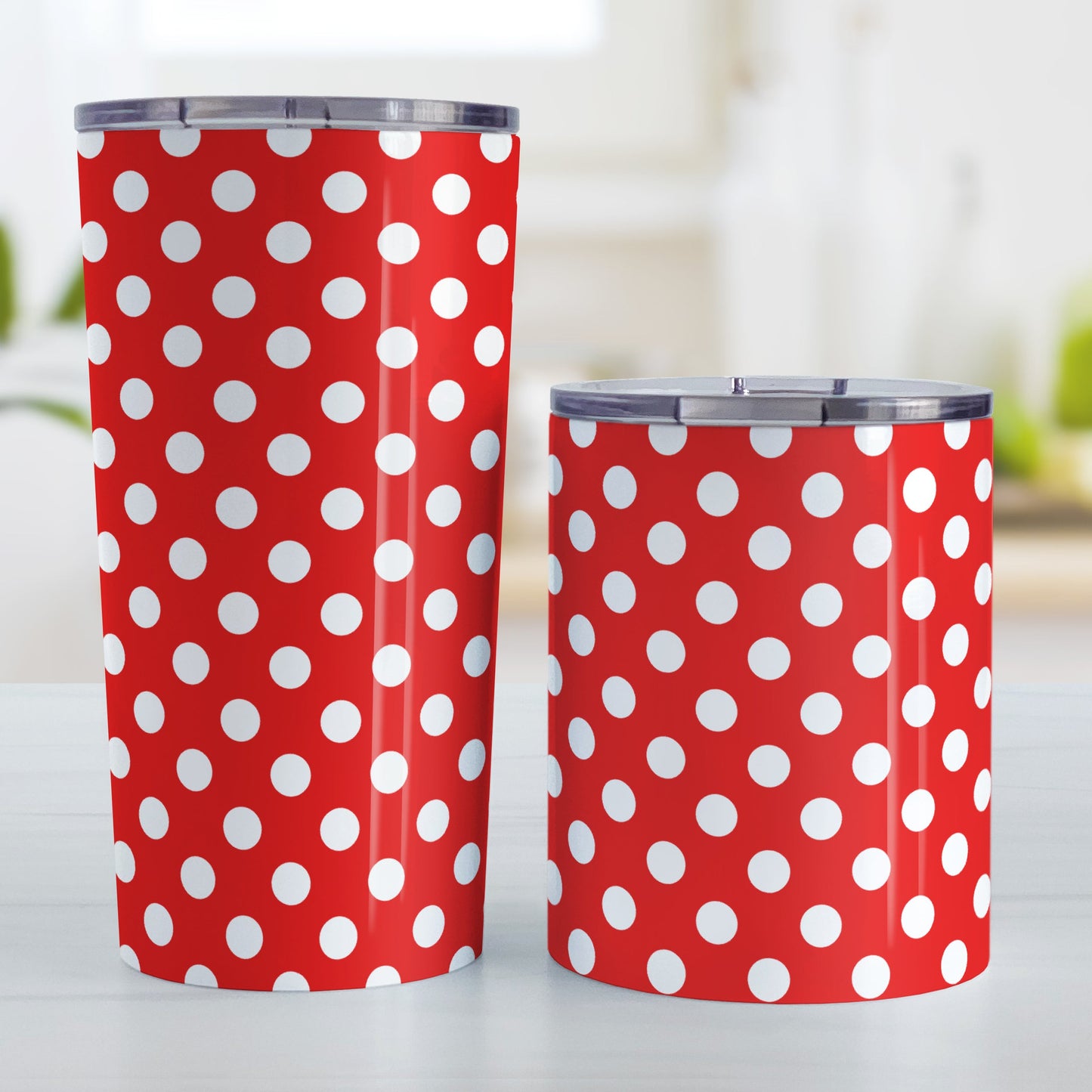 Red Polka Dot Tumbler Cup (20oz and 10oz, stainless steel insulated) at Amy's Coffee Mugs. A tumbler cup designed with a pattern of white polka dots over a red background color that wraps around the cup. Photo shows both sized cups on a table next to each other.