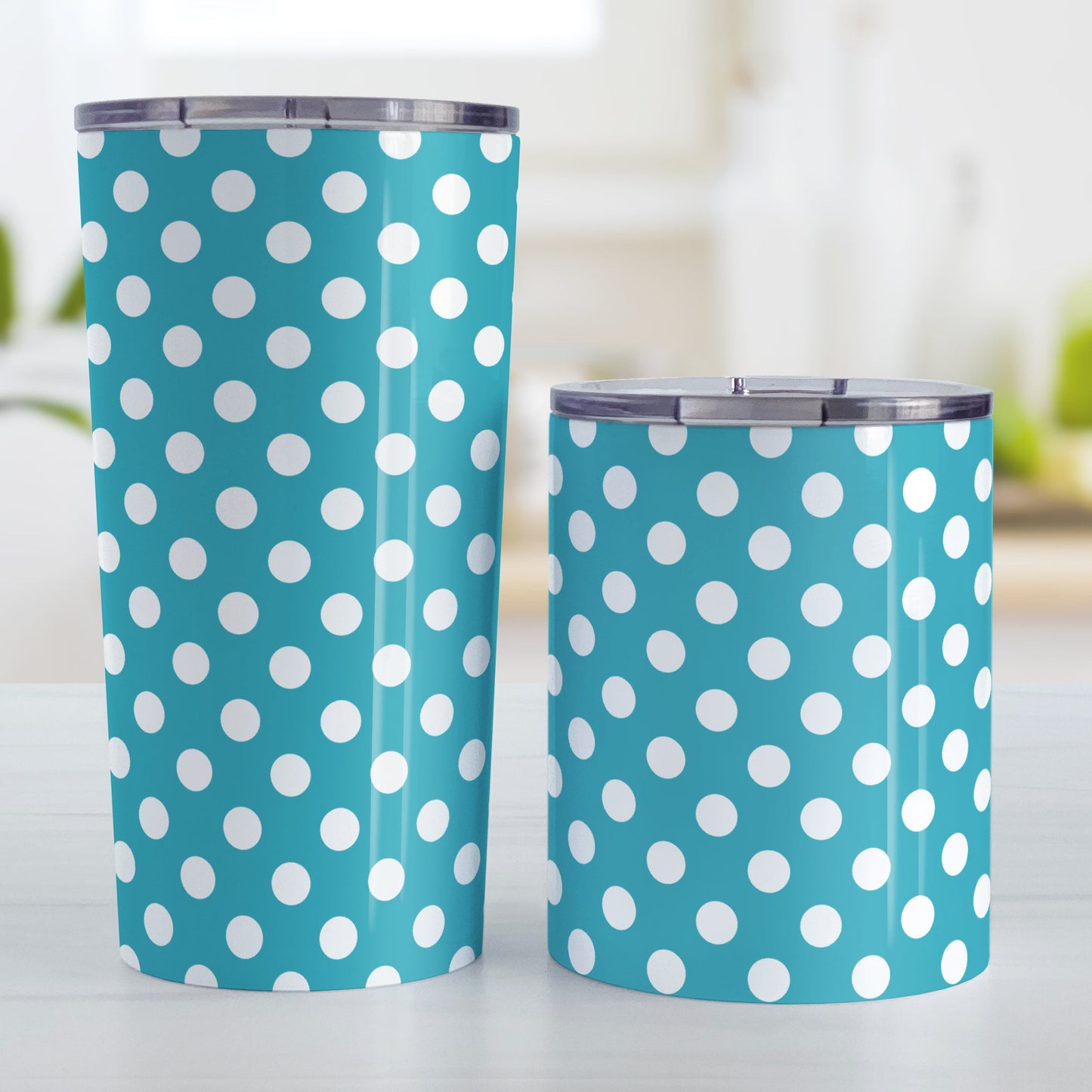 Turquoise Polka Dot Tumbler Cup (20oz and 10oz, stainless steel insulated) at Amy's Coffee Mugs. A tumbler cup designed with a pattern of white polka dots over a turquoise background color that wraps around the cup. Photo shows both sized cups on a table next to each other.