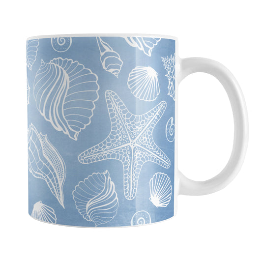 White Seashell Pattern Blue Beach Mug (11oz) at Amy's Coffee Mugs. A ceramic coffee mug designed with a pattern of white seashell line drawings over a beachy blue background that wraps around the mug up to the handle.