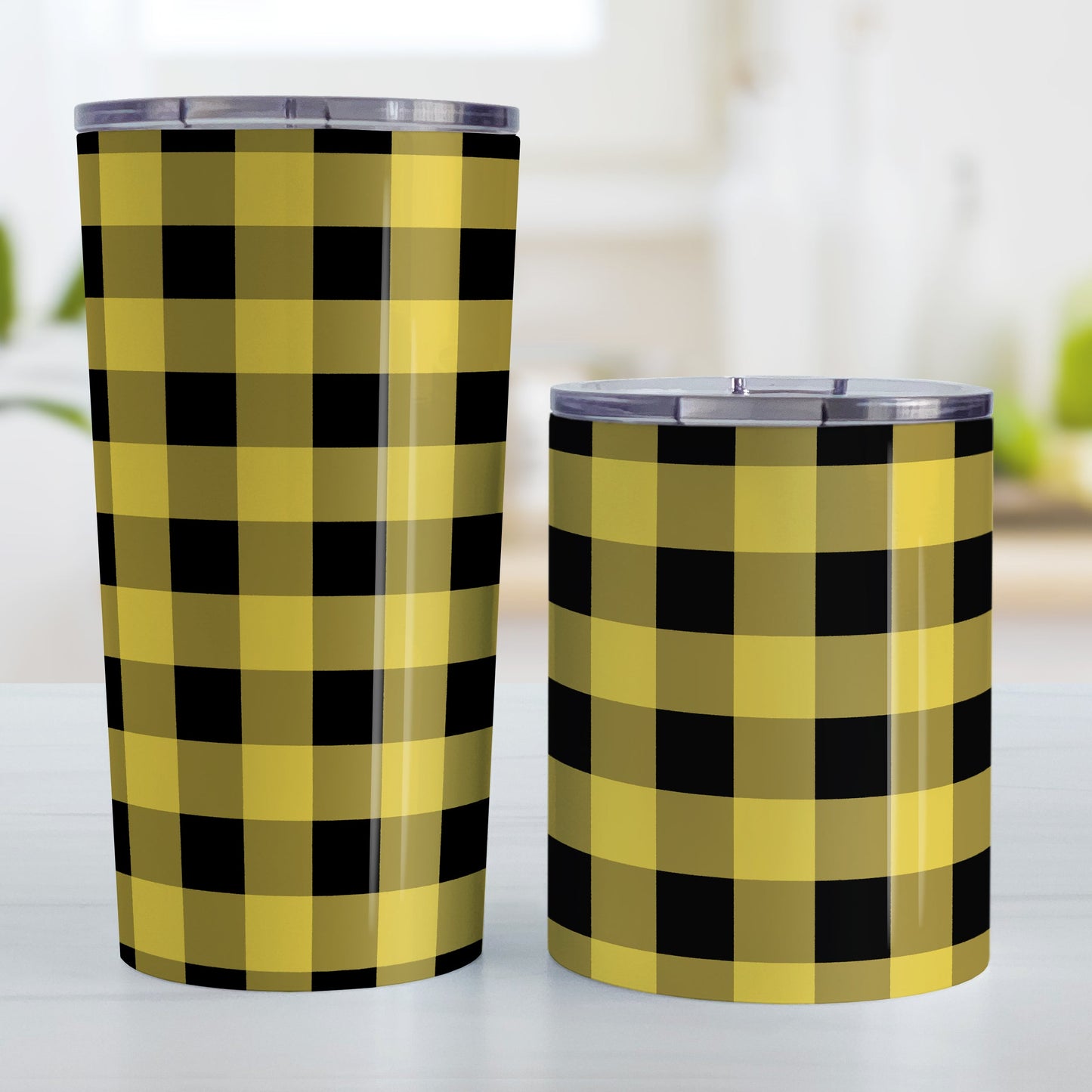 Yellow and Black Buffalo Plaid Tumbler Cup (20oz and 10oz, stainless steel insulated) at Amy's Coffee Mugs. Tumbler cups designed with a buffalo plaid pattern in black and yellow that wraps around the cups. Photo shows both sized cups on a table next to each other.