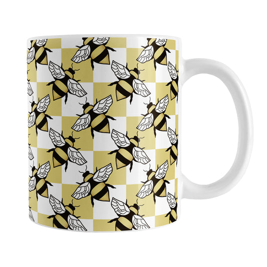 Yellow Checkered Bee Mug (11oz) at Amy's Coffee Mugs. A ceramic coffee mug designed with a an alternating pattern of black and yellow bees spaced evenly on the corners of a yellow and white checkered pattern that wraps around the mug up to the handle.