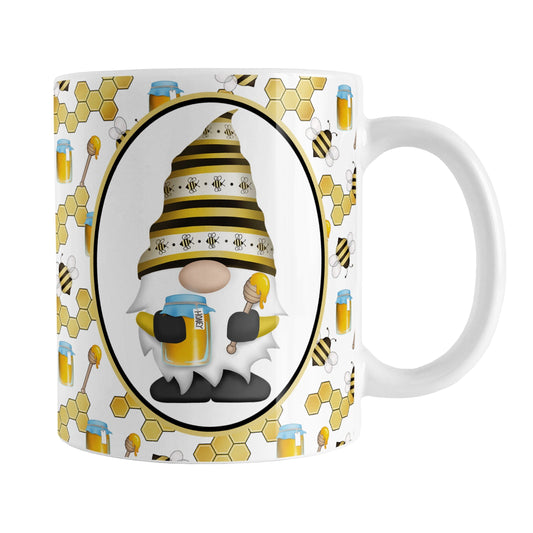 Yellow Gnome Honey Jar Bee Mug (11oz) at Amy's Coffee Mugs. A ceramic coffee mug designed with an adorable gnome wearing a yellow bee-themed hat and holding a honey jar and honey dipper in a white oval over a pattern background that wraps around the mug to the handle with bees, honey jars, honey dippers, and honeycomb.