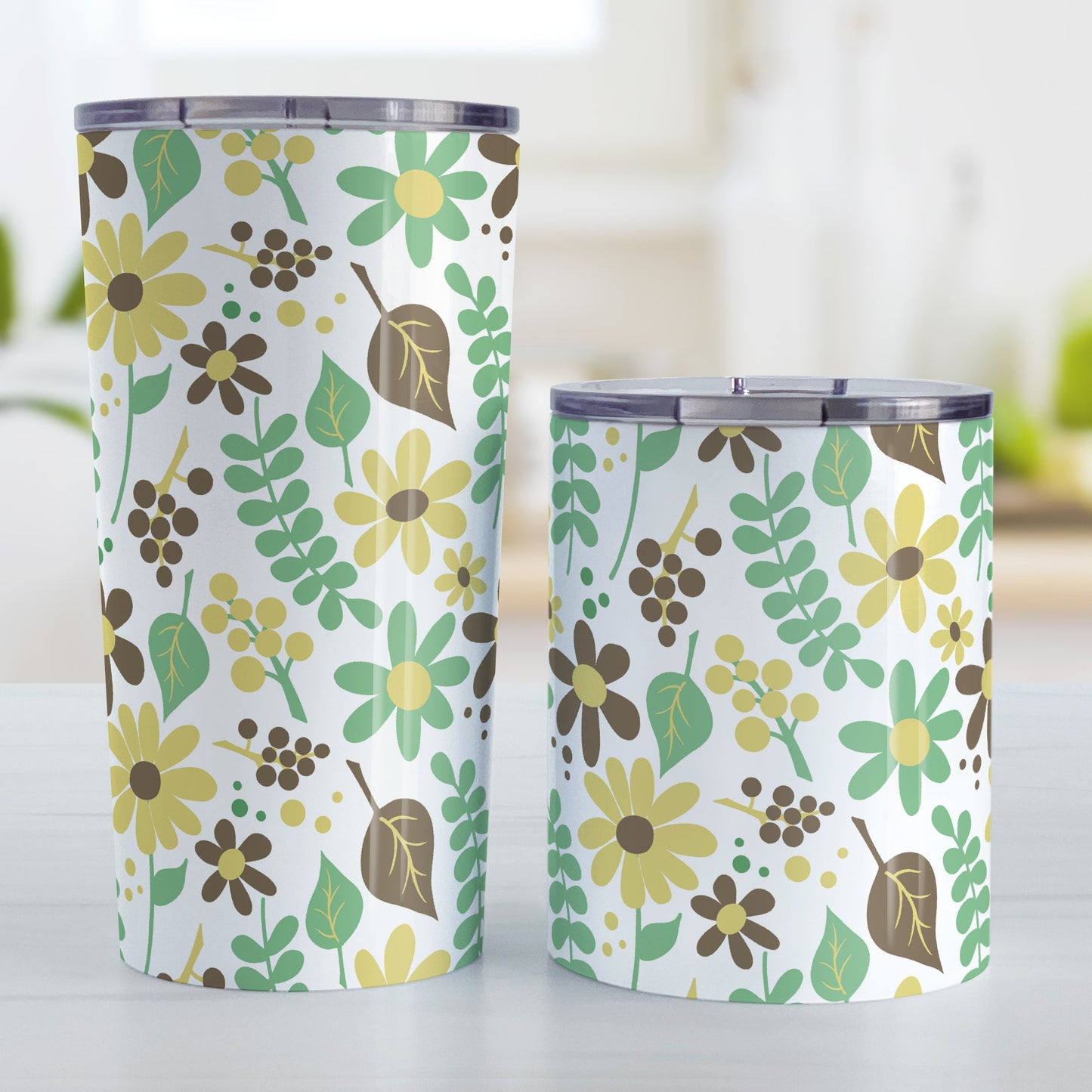 Yellow Green Brown Floral Pattern Tumbler Cup (20oz and 10oz, stainless steel insulated) at Amy's Coffee Mugs. Tumbler cups designed with a pretty floral pattern in yellow, green, and brown flowers and leaves that wraps around the cups. Photo shows both sized cups on a table next to each other.