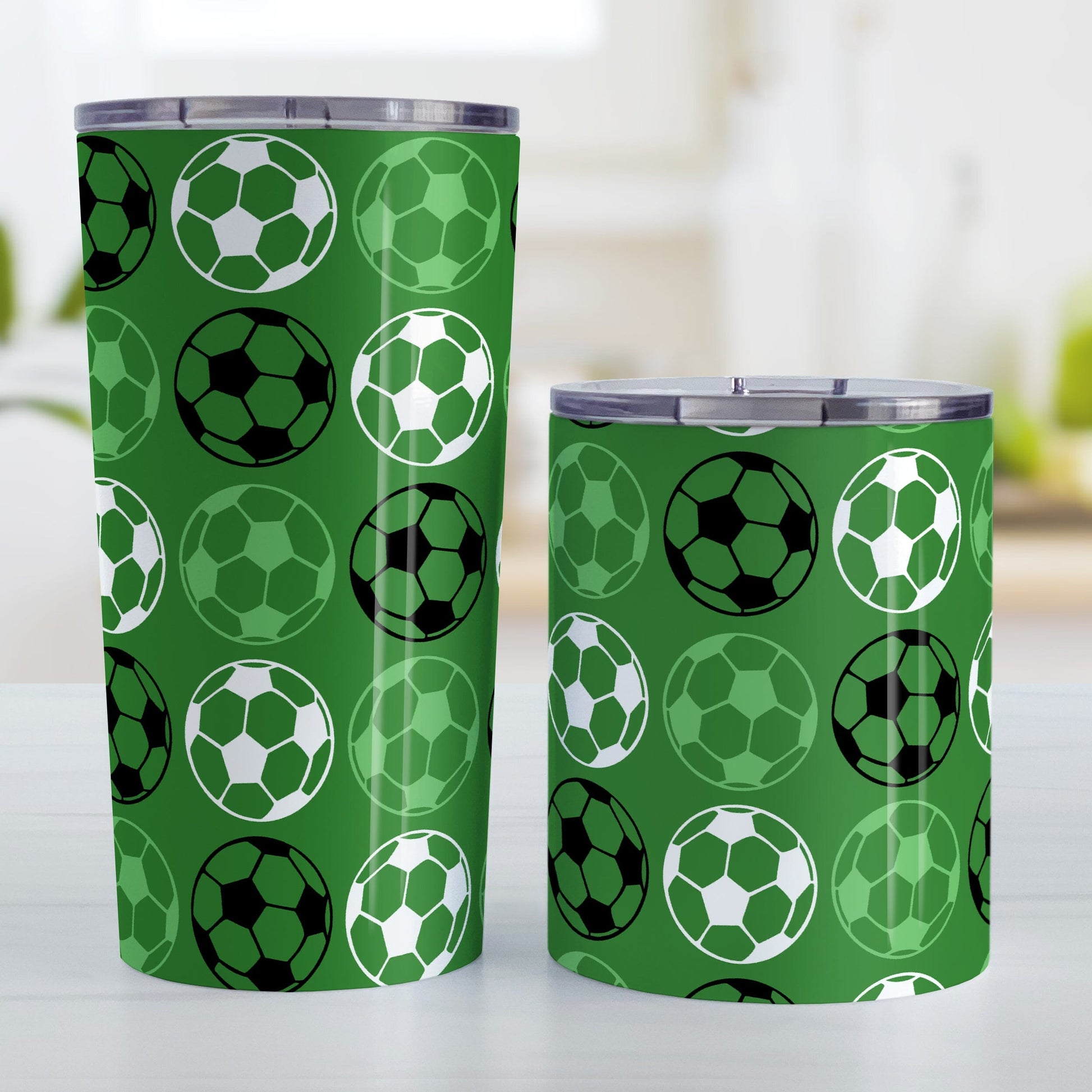 Alternating Dark Green Soccer Balls Tumbler Cup at Amy's Coffee Mugs. Photo shows both sized cups on a table next to each other.