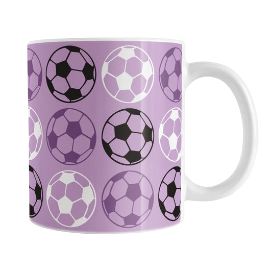 An 11oz white mug with a purple soccer ball pattern, over a white background