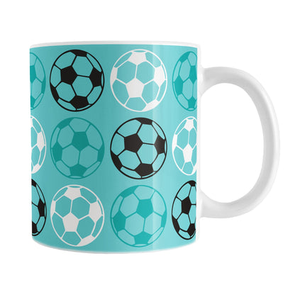 11oz white mug with a light teal soccer ball pattern, over a white background