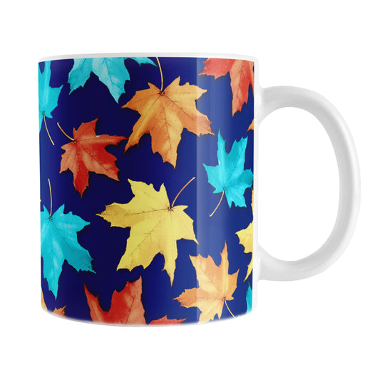 11 oz Blue Fall Leaves Mug with colorful turquoise, orange, red, and yellow autumn leaves over a deep navy blue background.