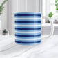 Mug with blue stripes on a marble surface with plants in the background