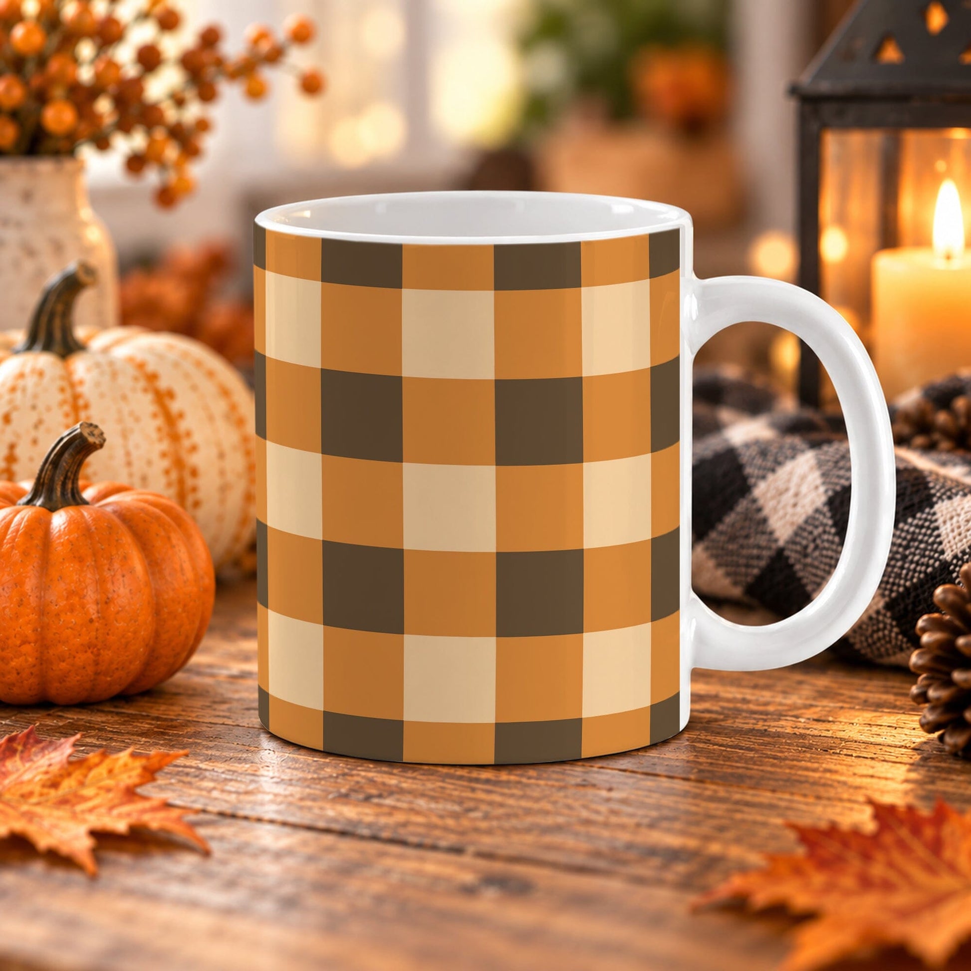 Brown and orange fall buffalo plaid coffee mug in 11 oz with large brown, orange, and beige checks on glossy white ceramic, displayed on a wooden table with cozy fall decor around it.