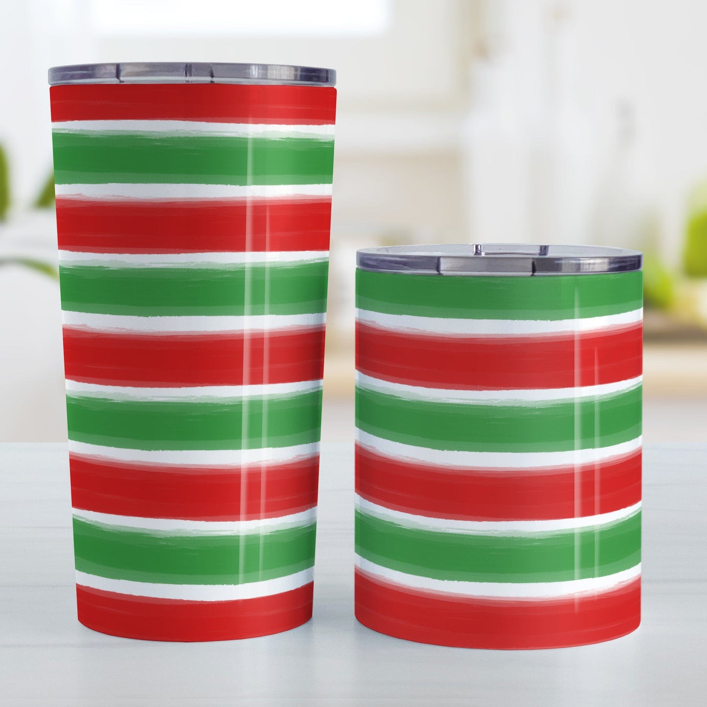 Christmas Paint Brush Strokes Tumbler Cup (20oz or 10oz) at Amy's Coffee Mugs. A stainless steel tumbler cup featuring a print of artistic paint brush strokes horizontally across the cup in alternating colors of red and green to celebrate the Christmas holiday. Photo shows both sized cups next to each other.