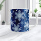 Mug with snowflake pattern on a blue background, placed on a white surface.