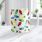 Mug with colorful Christmas light bulb pattern on a white surface.