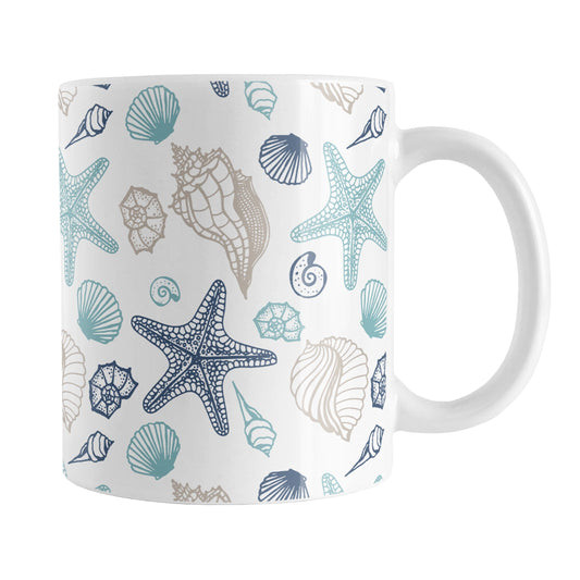 Coastal Seashells Pattern Mug (11oz) at Amy's Coffee Mugs. A ceramic coffee mug with a summer beach-inspired pattern of seashells in navy blue, teal, and sandy beige over white that wraps around the mug up to the handle.