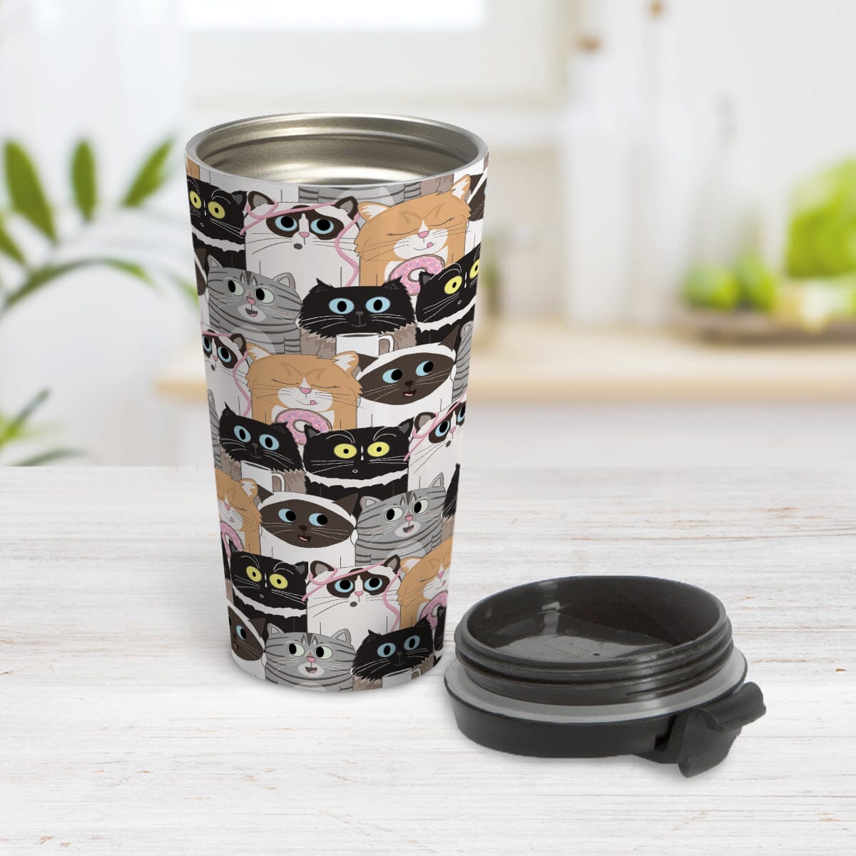 Cute Cat Stack Pattern Travel Mug (15oz) at Amy's Coffee Mugs. A cute stainless steel travel mug with an illustrated pattern of different breeds of cats with different fun expressions, with yarn, coffee, and donuts. This stacked pattern of cats wraps around the cup. Photo shows the travel mug open on a table with the lid laying beside it. 