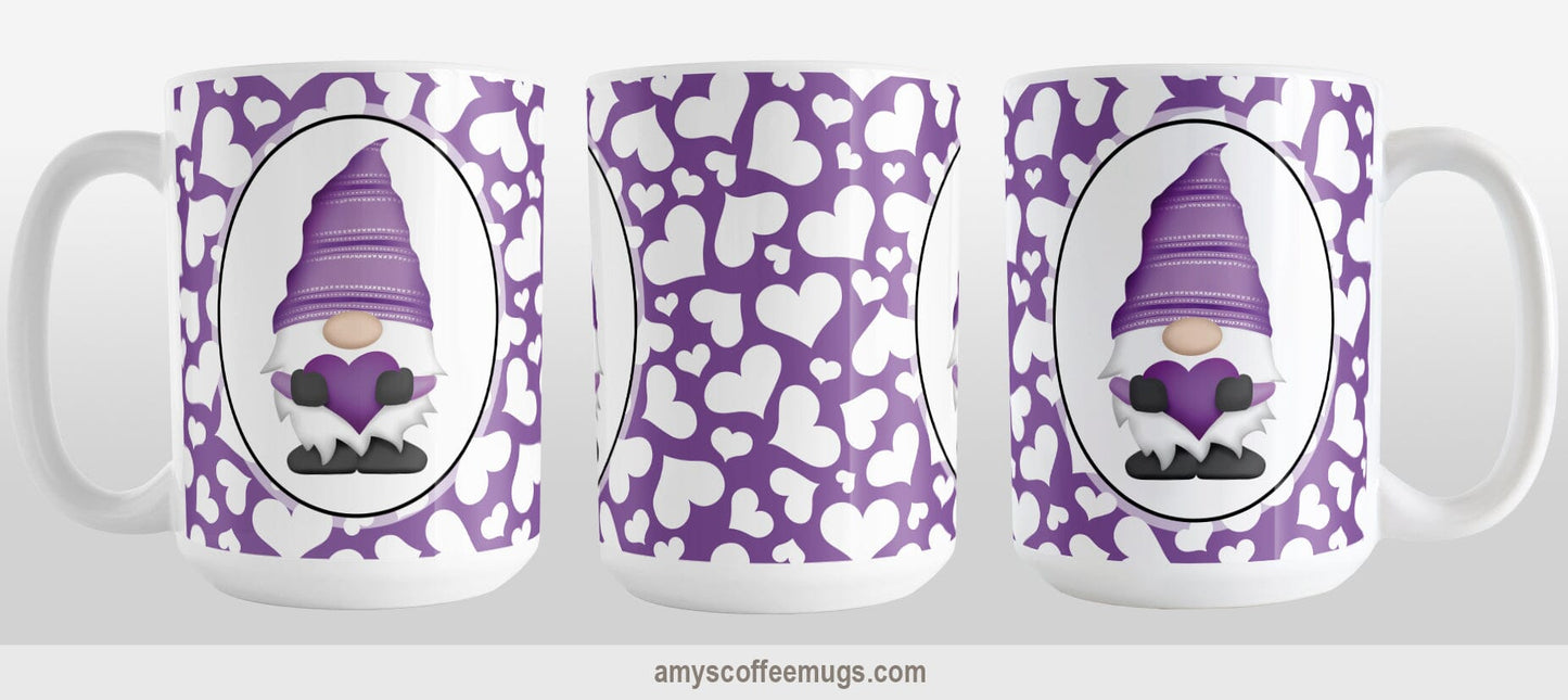 Cute White Hearts Purple Gnome Mug (15oz) at Amy's Coffee Mugs. A ceramic coffee mug designed with an adorable purple gnome in a white oval on both sides of the mug over a pattern of cute white hearts over a purple background that wraps around the mug to the handle. Image shows three sides of the mug to show the entire design.