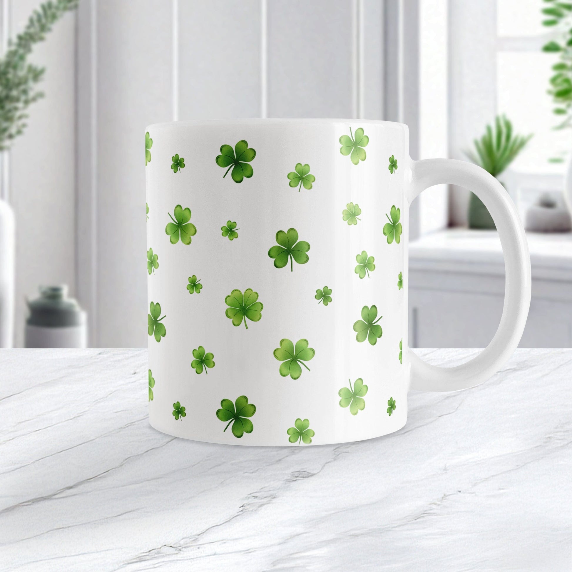 White mug with green clover pattern on a white marble surface