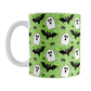 Mug with Halloween-themed design featuring ghosts, bats, and spiders on a green background.