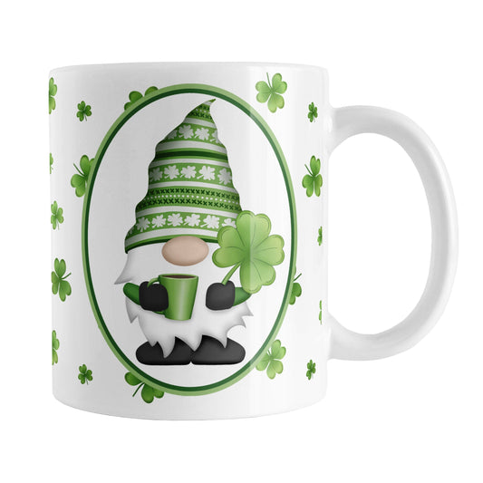 Green Gnome Dainty Shamrocks Mug (11oz) at Amy's Coffee Mugs. A ceramic coffee mug designed with an adorable green hat gnome holding a 4-leaf clover and a hot beverage in a white oval over a pattern of dainty green shamrocks in different shades of green that wrap around the mug to the handle.
