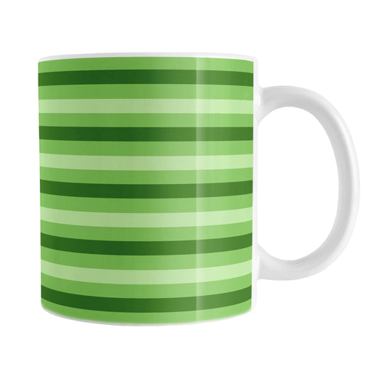 11oz white mug with green stripes in 3 shades in a pattern that wraps around the mug up to the handle