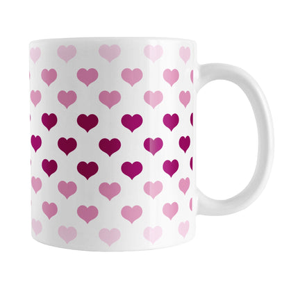 Hearts in Pink Mug (11oz) at Amy's Coffee Mugs. A ceramic coffee mug designed with hearts in different shades of pink, with the darker pink color across the middle and the lighter pink along the top and bottom, in a pattern that wraps around the mug to the handle. 