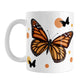 Monarch Butterfly Mug (11oz) at Amy's Coffee Mugs. A ceramic mug designed with an illustration of a monarch butterfly with orange circles and smaller black silhouette butterflies around it. This nature-inspired drawing is on both sides of the mug.