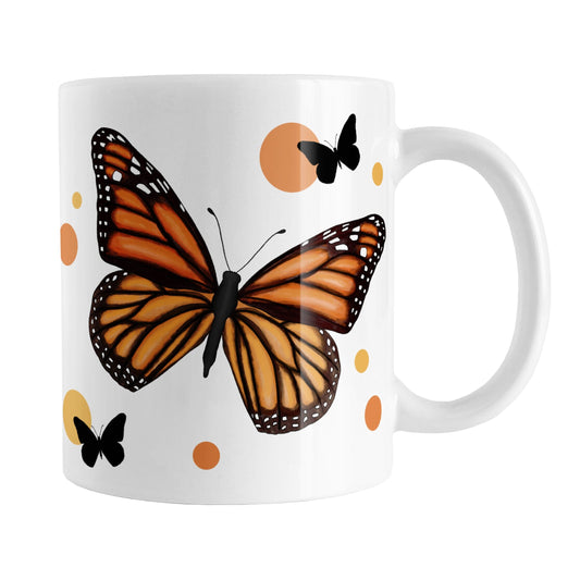 Monarch Butterfly Mug (11oz) at Amy's Coffee Mugs. A ceramic mug designed with an illustration of a monarch butterfly with orange circles and smaller black silhouette butterflies around it. This nature-inspired drawing is on both sides of the mug.