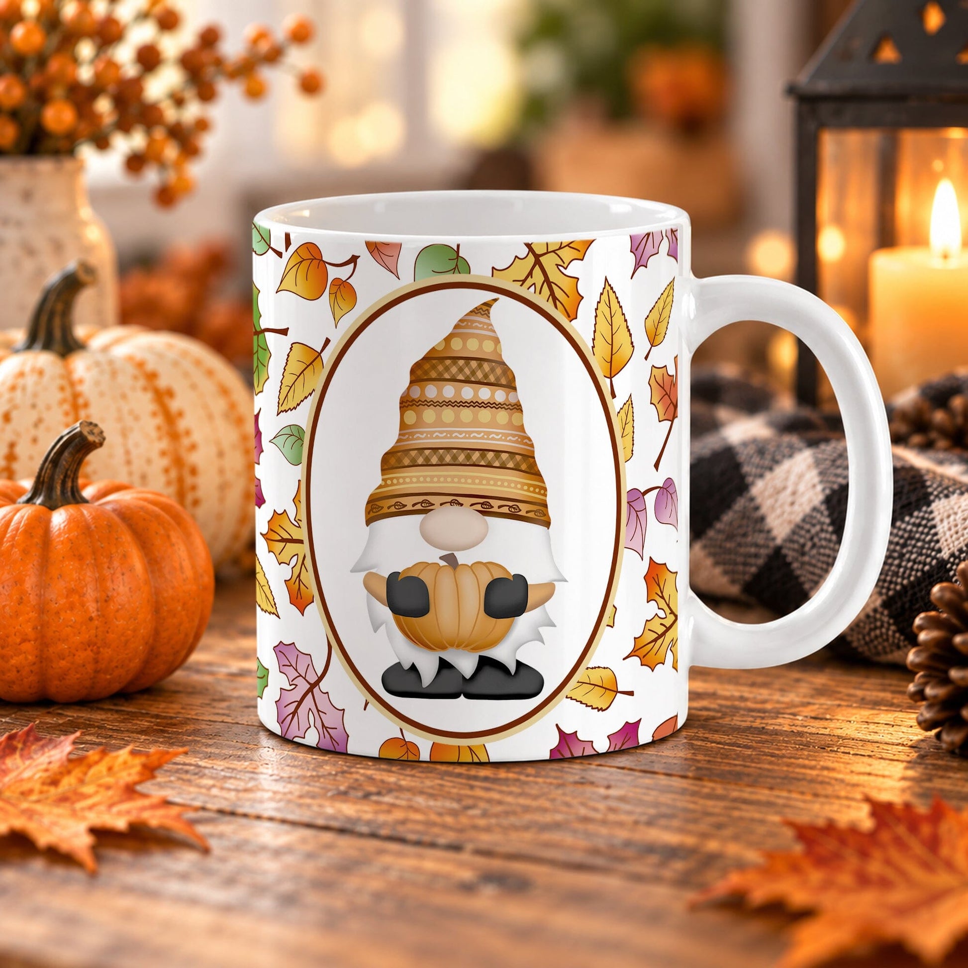 11 oz fall gnome mug with orange patterned hat, pumpkin, oval frame, and colorful autumn leaves on white ceramic, displayed on a wooden table with fall decor around it.