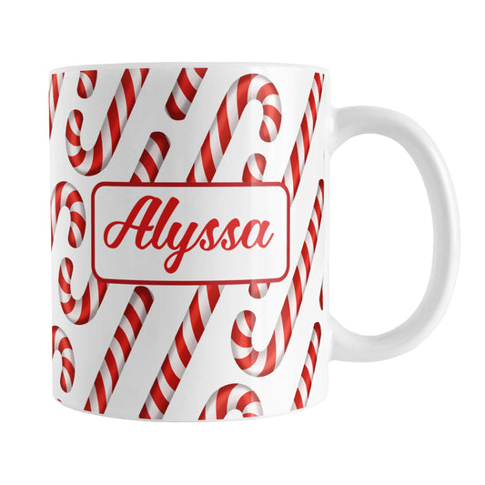 Personalized Candy Cane Pattern Mug (11oz, Red Name) at Amy's Coffee Mugs. A ceramic coffee mug designed with your personalized name in red on both sides of the mug over a pattern of diagonal candy canes that wraps around the mug up to the handle.