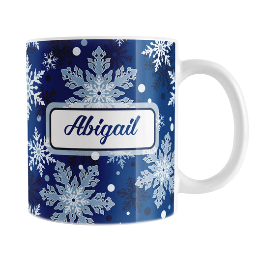 Personalized Classic Blue Snowflake Winter Mug (11oz) at Amy's Coffee Mugs. A ceramic coffee mug designed with a pattern of different shades of blue snowflakes over a classic blue background color that wraps around the mug to the handle. Your name is custom printed in a blue script font on both sides of the mug. 