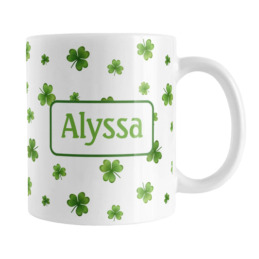 Personalized Dainty Shamrocks and Clovers Mug (11oz) at Amy's Coffee Mugs. A ceramic coffee mug designed with a print of hand-drawn green shamrocks and 4-leaf clovers in a dainty minimalist pattern that wraps around the mug up to the handle. Your personalized name is custom-printed on both sides of the mug in green.