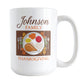 Personalized Family Thanksgiving Dinner Mug (15oz) at Amy's Coffee Mugs. A ceramic coffee mug designed with an illustration of a holiday turkey dinner place setting on both sides of the mug. Your family name is custom printed in a brown script font along with "family Thanksgiving" in orange, printed in continuance above and below the place setting design.