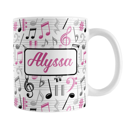 Personalized Pink Music Notes Pattern Mug (11oz) at Amy's Coffee Mugs. A ceramic coffee mug designed with music notes and symbols in pink, black, and gray in a pattern that wraps around the mug to the handle. Your personalized name is custom printed in a pink script font on white over the music pattern design on both sides of the mug. 