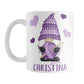 Personalized Purple Crochet Gnome Mug (11oz) at Amy's Coffee Mugs. A ceramic coffee mug designed with a cute gnome wearing a purple crochet hat while holding a ball of purple yarn and a crochet hook with purple hearts around him. Your name is printed in a fun purple font below the gnome. This adorable illustration and personalization is on both sides of the mug. 