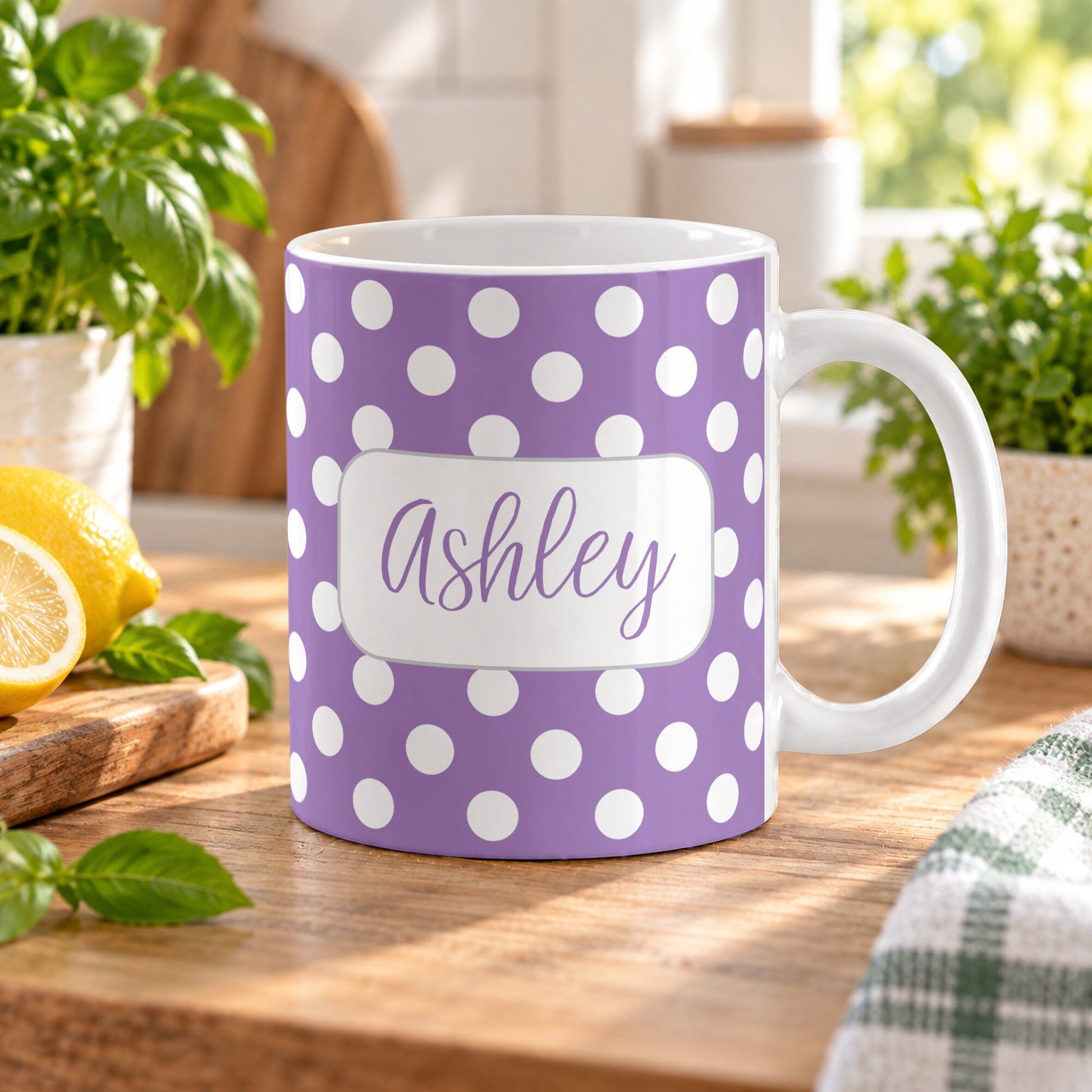 11 oz personalized purple polka dot mug with white dots and custom name in purple script, shown on a wooden table in a bright spring kitchen with green plants and lemons on a cutting board.