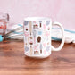 Pink Baking Pattern Mug (15oz) from Amy's Coffee Mugs on a table with baking supplies. 